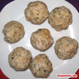 Mit einem Schaumlöffel die Knödel aus dem Wasser holen und in einen Teller legen.