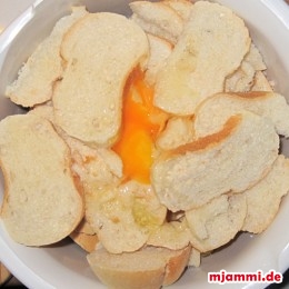 Die zwei Eier aufschlagen und in die Schüssel mit den Semmeln geben.
