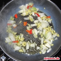 Ψήνουμε τα κρεμμύδια, την πιπερόριζα και τις καυτερές πιπεριές σε μια κουταλιά ελαιόλαδο σε ένα τηγάνι.