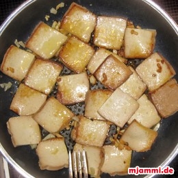 Das Öl in eine Pfanne geben und die Knoblauchzehen anrösten. Den Tofu rechts und links 2 min. anbraten. 