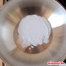 Von der Kokosmilch die dicke Creme, die sich oben absetzt in einen Wok geben.