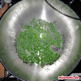 Im Wok 1 EL Öl erhitzen und die Erbsen mit ein wenig Salz und 2 EL Wasser 5 Minuten mit Deckel dünsten. Dann die Erbsen in einen Teller füllen und beiseite stellen.