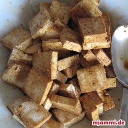 Tofu in Stücke schneiden. In heller Sojasauce marinieren.