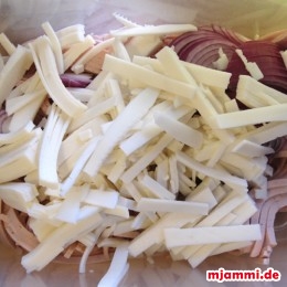 Den Käse in dünne Scheiben schneiden und dazu geben.
