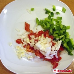 Zuerst die Tomate, Zwiebel und grüne Paprika in kleine Würfel schneiden.