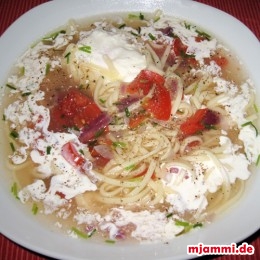 Wenn die Nudeln gut sind, dann kommen die Tomaten, Zwiebeln und der Schnittlauch rein. Auf dem Teller anrichten, mit ein paar Tropfen Sahne und ein bißchen Pfeffer würzen.