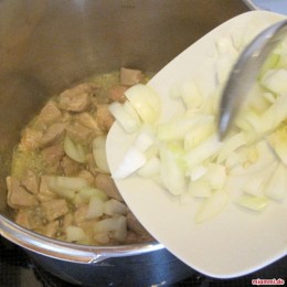 Sobald das Fleisch etwas angebraten ist geben wir die gehackte Zwiebeln und die zerdrückten Knoblauchzehen hinzu.