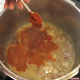 Das Fleisch nach Geschmack salzen und zwei Teelöffel Paprika dazu geben. Mit Wasser aufgießen bis alles bedeckt ist und die Brühe köcheln lassen.