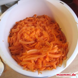Zuerst die Möhren schälen und raspeln.