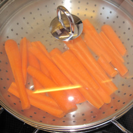 Τοποθετούμε το ένθετο καλάθι για μαγείρεμα στον ατμό και αφήνουμε τα καρότα για 10-12 λεπτά στον ατμό. Κατά την διάρκεια αυτή πρέπει τα καρότα να μείνουν τραγανά και να μην μαλακώσουν πολύ.