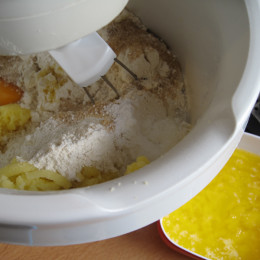 Die Kartoffeln reiben und mit Mehl, Zucker, der geschmolzenen Butter, Backpulver und Ei  ...