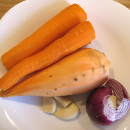 Zuerst die Möhren, die Süßkartoffel, die Zwiebeln, die Knoblauchzehen ganz grob schneiden.