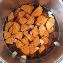 Dann im Topf die Zwiebeln in ein bißchen Wasser anbraten. Die Möhren, Süßkartoffel und Knoblauchzehe mit 1,5 l Wasser kochen.