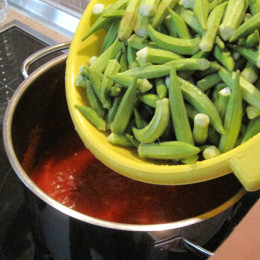 Dann die Okraschoten hineingeben, nicht in der Soße umrühren, nochmals eine halbe Tasse Wasser hinzugeben und 10-15 Minuten kochen lassen mit geschlossenem Deckel.