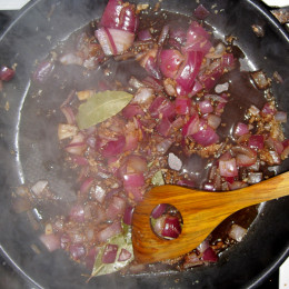 4 Lorbeerblätter in einem Topf anbraten. 4 Knoblauchzehen hineinpressen. Zwiebeln dazugeben. Wenn die Zwiebel glasig sind, etwas Balsamicoessig darunterrühren.