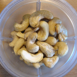 Cashews, Zesten und Saft einer halben Zitrone und 1/2 TL Salz in einen Mixer geben.