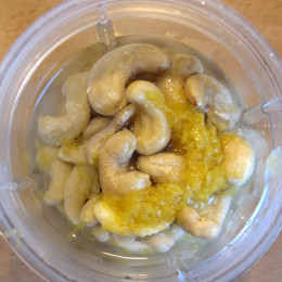 Cashews, Zesten und Saft einer halben Zitrone und 1/2 TL Salz in einen Mixer geben.