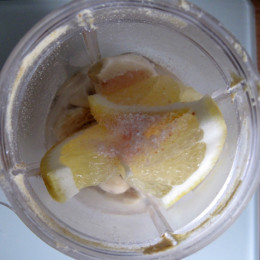 Cashews mit 50 ml Wasser, der Knoblauchzehe und einer Scheibe Zitrone in einem kleinen Mixer zu Cashew-Joghurt mixen.